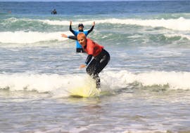 A young surfer is riding their first wave during their surfing lessons for beginners with Algarve Adventure.