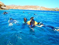 Eine Familie, die ihren Schnorchelauslfug auf Mykonos zusammen mit einem lokalen Guide des Mykonos Diving Center genießt.
