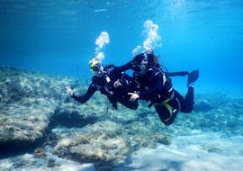 A woman enjoying her first diving experience in her Discover Scuba Diving Tour in Mykonos together with an experienced instructor from Mykonos Diving Center.