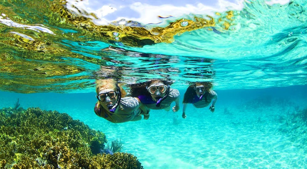 Tour participants bathe in crystal clear water during the Sailing Catamaran Tour with Snorkeling, Paella & Drinks organized by Robinson Boat Trips.