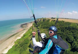 A man is enjoying his Tandem Paragliding "Omaha Beach" - Normandie with Parapente Mania.