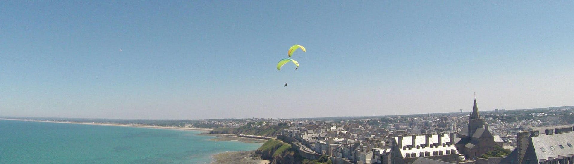 Two persons are enjoying the activity Tandem Paragliding "Granville" - Normandie with Parapente Mania.