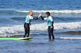 Un élève remerciant son instructeur après une journée réussie dans l'eau tout pendant une séance de cours de surf privés avec Ocean Life Surf School.