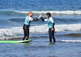 Un élève remerciant son instructeur après une journée réussie dans l'eau tout pendant une séance de cours de surf privés avec Ocean Life Surf School.
