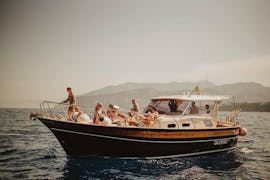 Boot van Capitano Ago met mensen op het dek aan het navigeren tijdens Boottocht van Sorrento naar Positano en Amalfi.