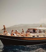 Barca del Capitano Ago con persone sul ponte che navigano durante la gita in barca da Sorrento a Positano e Amalfi.