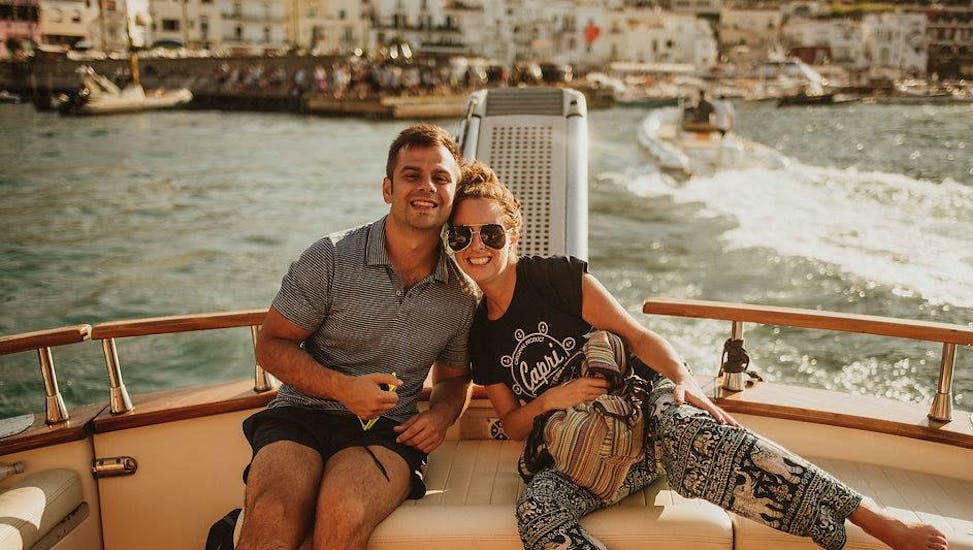 Una pareja sonríe para la foto en el barco de Capitano Ago durante el viaje en barco privado de Nápoles a Capri.