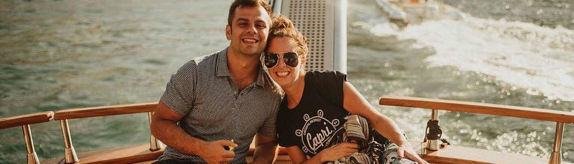 Una pareja sonríe para la foto en el barco de Capitano Ago durante el viaje en barco privado de Nápoles a Capri.