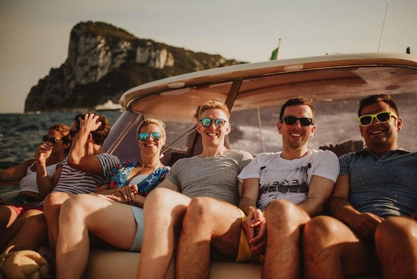 Un grupo de amigos tumbados en el barco y disfrutando del sol durante el viaje en barco privado de Amalfi a Capri con Capitano Ago.