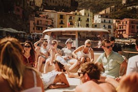 Un grupo de personas tumbadas en el barco y disfrutando del sol durante el viaje en barco privado de Sorrento a Amalfi y Positano con Capitano Ago.