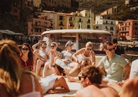 Un grupo de personas tumbadas en el barco y disfrutando del sol durante el viaje en barco privado de Sorrento a Amalfi y Positano con Capitano Ago.