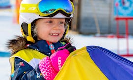 A kid having fun during the Kids Ski Lessons "Bambini MAX 4" (2-3 y.) for Beginners with Snow Sports School Eichenhof St. Johann.