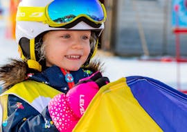 A kid having fun during the Kids Ski Lessons "Bambini MAX 4" (2-3 y.) for Beginners with Snow Sports School Eichenhof St. Johann.