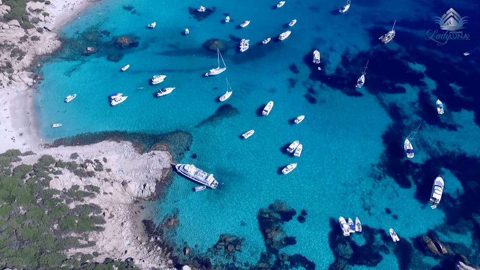 Quelques bateaux s'approchent de l'une des magnifiques plages de Sardaigne pendant l'excursion en bateau de Palau à l'archipel de La Maddalena.