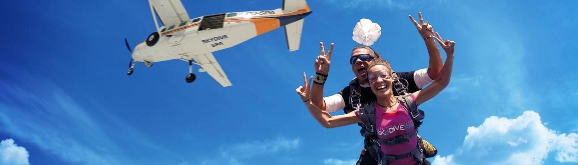 Une femme apprécie son saut en parachute avec un pilote de tandem qualifié de Skydive Spa & Cerfontaine à une altitude de 4 000 m au-dessus de Spa.