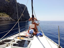 2 niñas descansan en el barco durante la excursión en velero privado a Sa Calobra desde Port de Sóller con Let's Sail Mallorca.