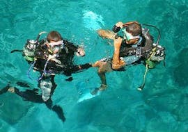 Two persons are preparing for the Trial Scuba Diving in Réserve Cousteau for Beginners with Les Heures Saines Guadeloupe.