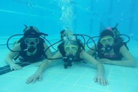 3 Friends trying their first dive during the PADI Scuba Diver Course for Beginners in Santa Maria  in the pool with Haliots Santa Maria.