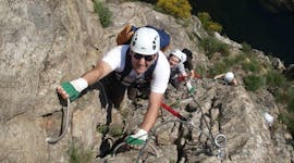 Des amis escaladent une falaise au-dessus de la rivière Ardèche lors de leur Via Ferrata en Ardèche - Pont du Diable avec Geo Ardèche Canyon.