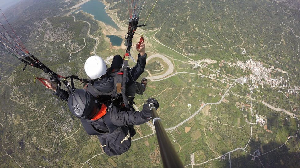 During the tandem paragliding above Heraklion, a woman is enjoying spectacular views in the good hands of a certified tandem pilot from Cretan Paragliding.