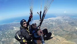 Tijdens het tandemparagliden boven Chania heeft een man het erg naar zijn zin met een gecertificeerde tandempiloot van Cretan Paragliding.