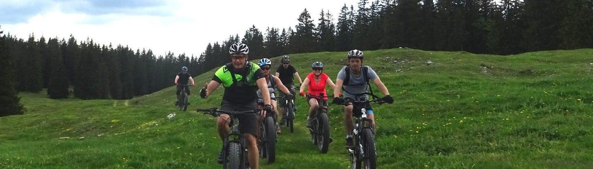 A family is doing the Mountain Bike Tour "Jura Ridges" - All Levels activity with La Boîte à montagne.