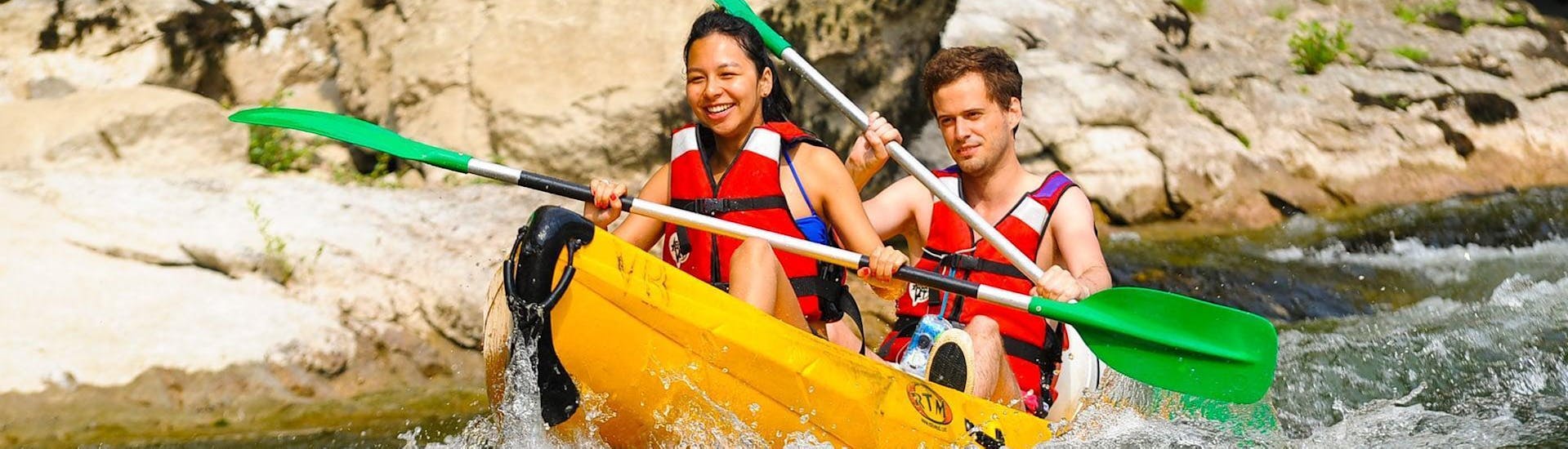 Dos personas reman por el río Ardèche y se divierten durante su alquiler de canoas de 8 km en Ardèche - Mini tour, con ALB Canoes.