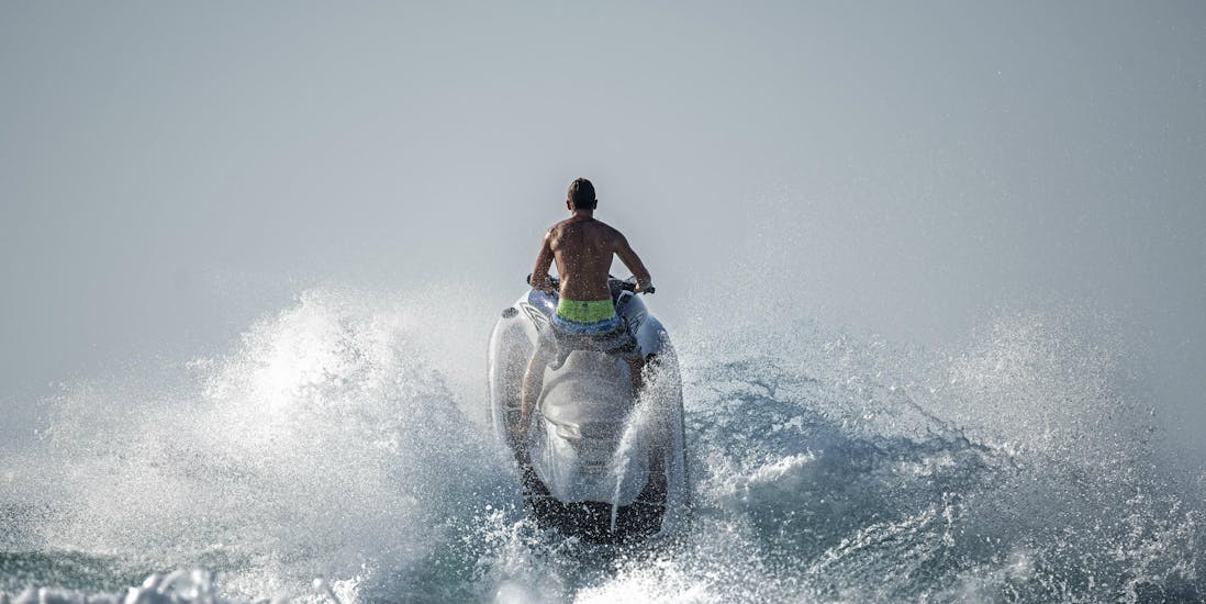 Un uomo cavalca una moto d'acqua nella baia di Ixia con Windsurfers World Rhodes.