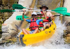 A father and his two kids are paddling down the Ardèche river and are having fun during their Canoe Rental in Ardèche - Maxi-Tour 12km with ALB Canoes.