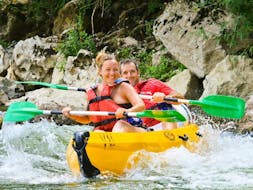 Two people are paddling down the Ardèche river and are having fun during their Canoe Rental in Ardèche - Adventure Tour 24km with ALB Canoes.
