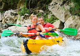 Two people are paddling down the Ardèche river and are having fun during their Canoe Rental in Ardèche - Adventure Tour 24km with ALB Canoes.
