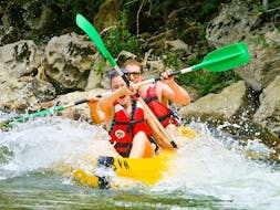 Two people are paddling down the Ardèche river and are having fun during their Canoe Rental in Ardèche - Sports Tour 32km with ALB Canoes.