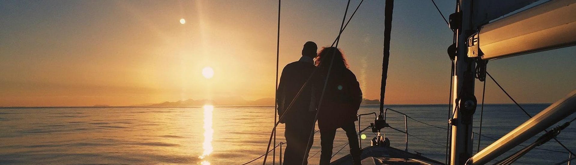 During the Private Sunset Sailing Tour with Romantic Dinner - Barcelona which is organised by Five Star Barcelona, a couple is enjoying the unique moments in the open sea when the sun disappears behind the horizon.