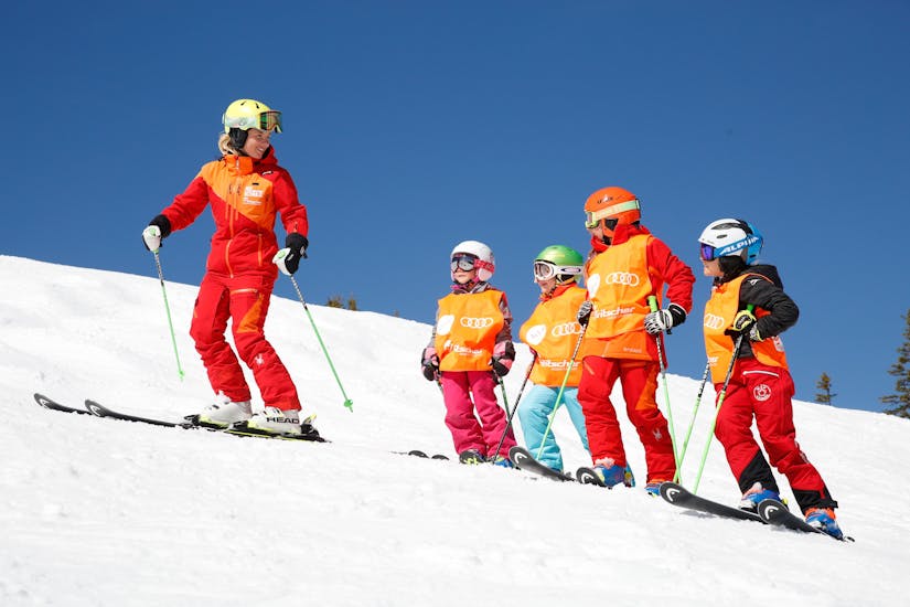 Een instructeur en vier kinderen staan op een piste bij de Kids Skilessen "Miniclub" (3-4 j.) in Rohrmoos.