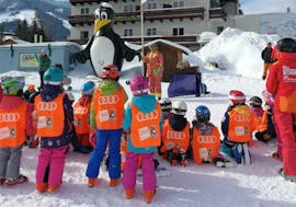 Un groupe d'enfants pendant leurs cours de ski pour enfants Miniclub avec skischule Tritscher.