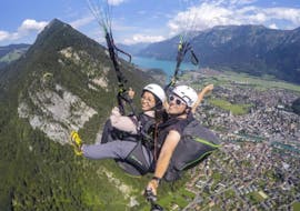A tandem pilot from Skywings Interlaken and his passenger are taking a selfie to commemorate their Tandem Paragliding in Interlaken - "The Thermal" flight.