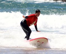 Une jeune femme apprend à surfer lors de son Cours de Surf pour Enfants & Adultes - Débutant avec Amado Surf School.