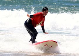 A young girl is learning how to surf during her Surfing Lessons for Kids and Adults - Beginner with Amado Surf School.