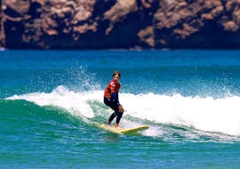 Un enfant montre ses compétences de surf lors d'un Cours de Surf pour Enfants & Adultes - Avancé avec Amado Surf School.