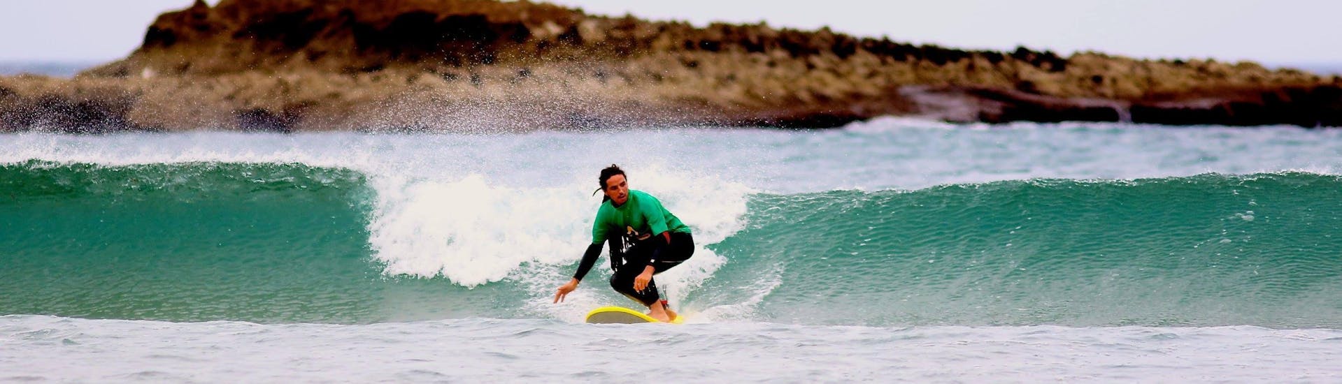 A young surfer is riding a wave during a Private Surfing Lessons for Kids and Adults - All Levels with Amado Surf School.