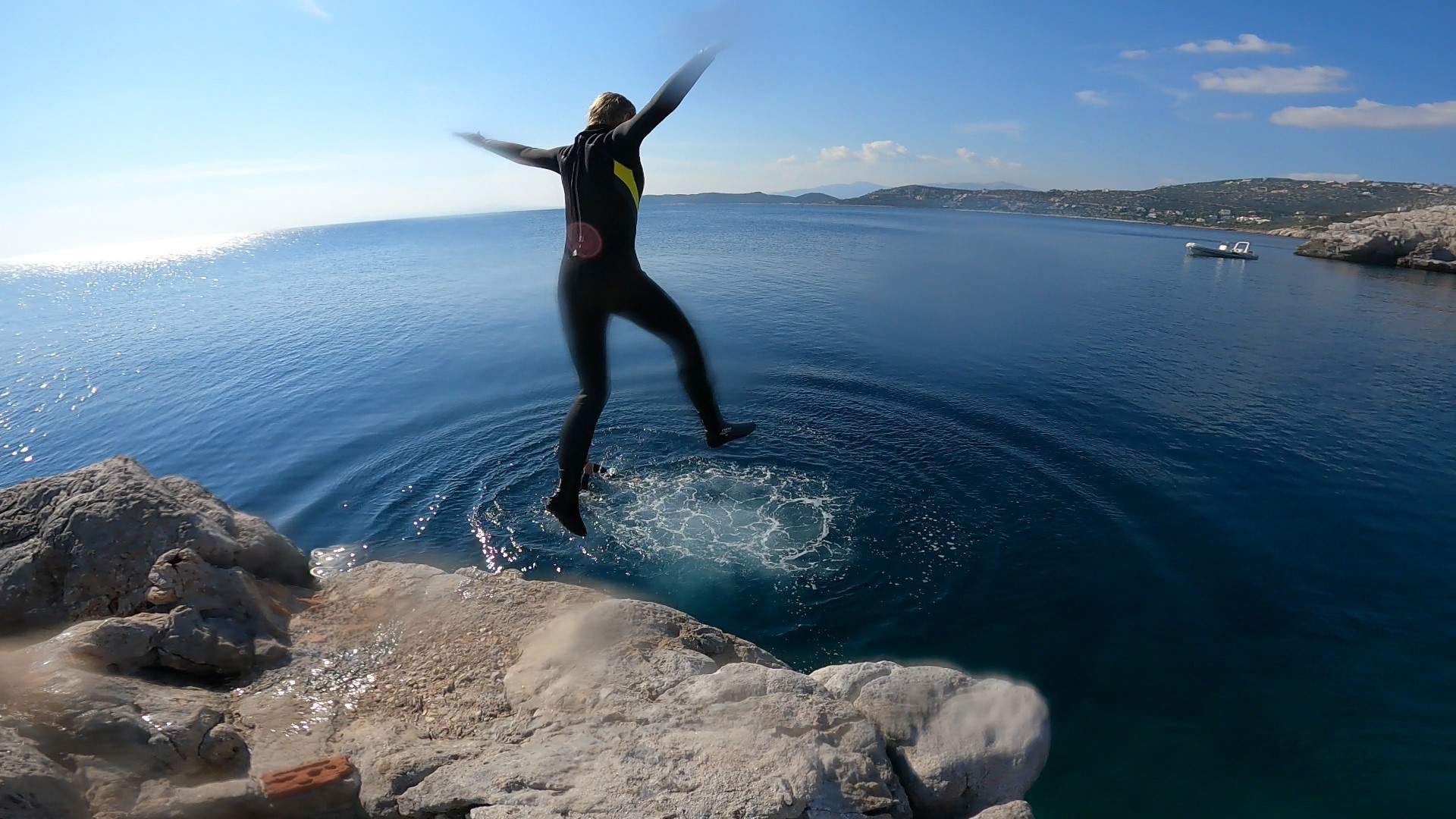 Man jumping during the boat tour with snorkeling and cliff jumping near Athens hosted by Kanelakis Diving Experiences - Dimitris Kanelakis.