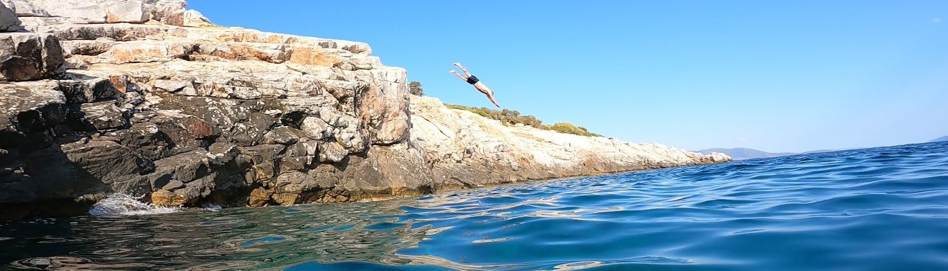 Una persona si immerge durante la Gita in barca con snorkeling e salto dalle scogliere vicino ad Atene con Kanelakis Diving Experiences Nea Makri.