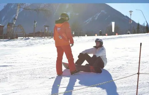 Privater Snowboardkurs für alle Levels & Altersgruppen mit Skischule Tritscher Schladming Ein Skilehrer der Skischule Tritscher unterrichtet Snowboarden während eines privaten Snowboardkurses für alle Niveaus und Altersgruppen.