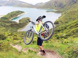 A kid is carrying his bike before starting the Mountain Bike Tour around Lagoa das Furnas on São Miguel with Picos de Aventura Azores.