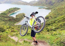 A kid is carrying his bike before starting the Mountain Bike Tour around Lagoa das Furnas on São Miguel with Picos de Aventura Azores.