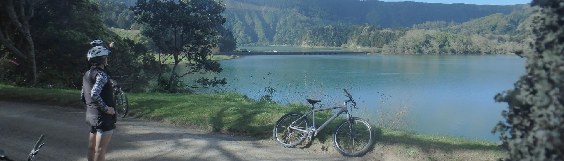 A girl is admiring the stunning view that you can see during the Mountain Bike Tour in Sete Cidades on São Miguel.