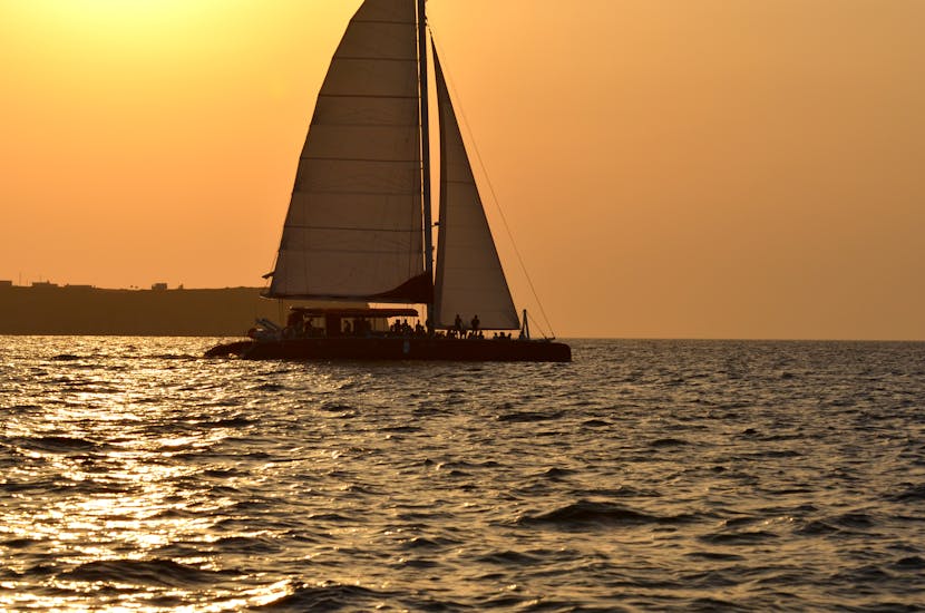 Foto van de catamaran met zonsondergang tijdens de catamarantocht in Santorini naar het Rode Strand bij zonsondergang met Sunset Oia.