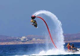 Flyboarding at Saint George Beach - with Flisvos Watersports 1974 Naxose. A person on a flyboard during flyboarding at Saint George Beach - with Flisvos Watersports 1974 Naxose.