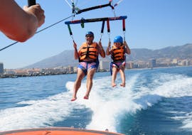 Foto van twee mensen die genieten van hun Parasailing tot 400m in Fuengirola - Vlieg tot 3 samen met Pirate Parasailing Fuengirola.