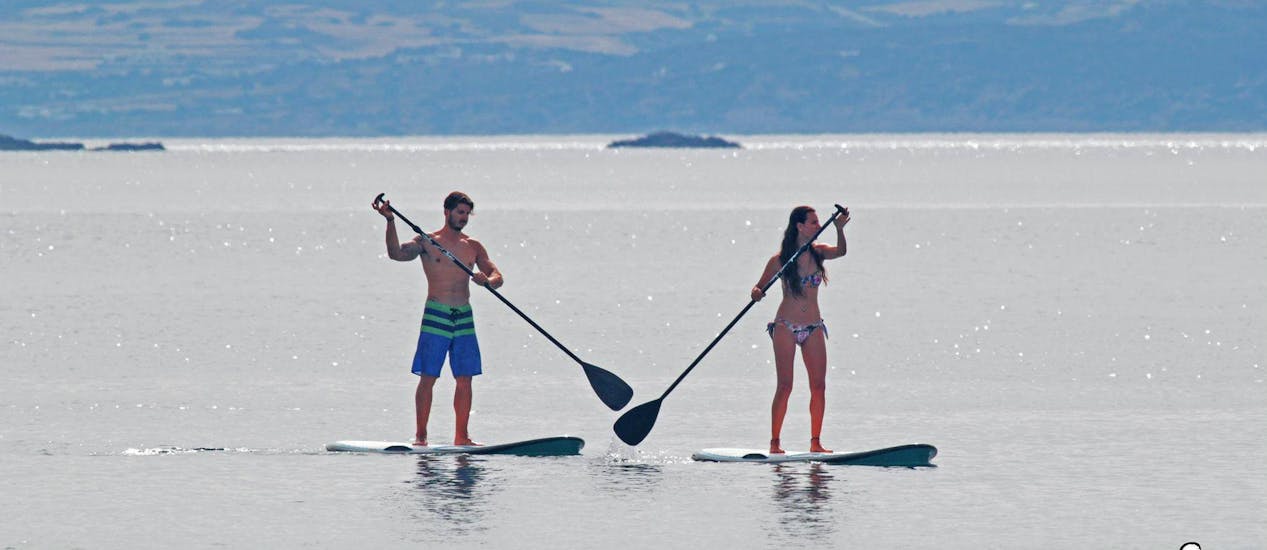 Two persons on a SUP board during SUP Rental at Saint George Beach with Flisvos Watersports 1974 Naxos.
